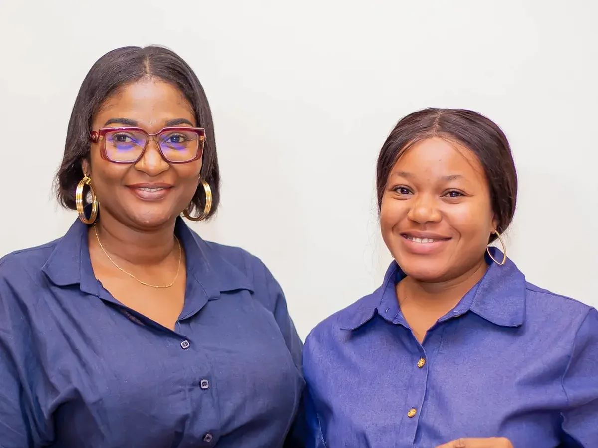 Deux bénéficiaires de la fondation, souriantes, leur attestation en main