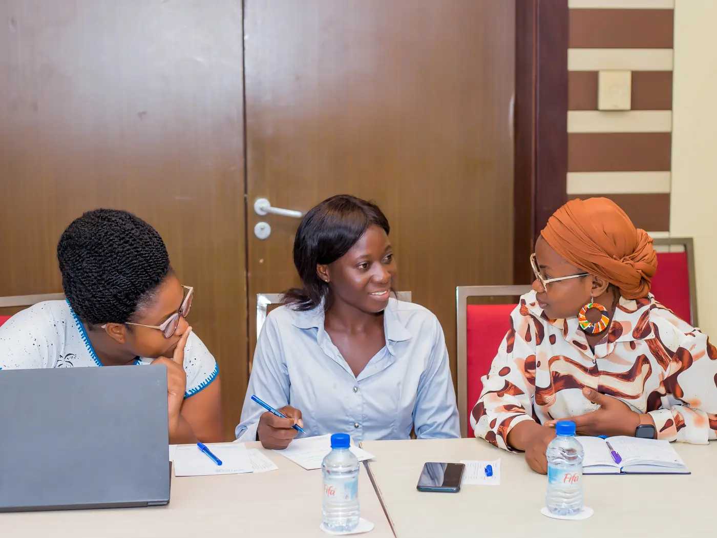 Trois jeunes femmes au travail pendant une session de Conversations Inspirantes, l’une sur son ordinateur