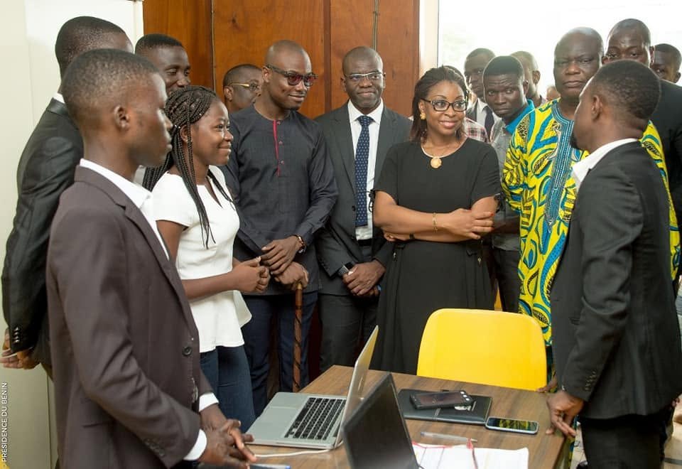 Aurélie Adam Soulé échange avec un groupe réuni autour d’une table et d’ordinateurs
